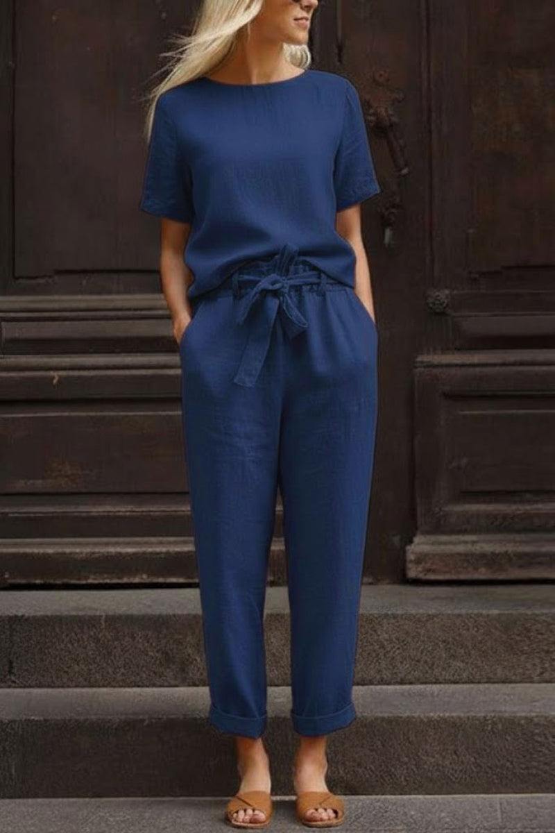 Woman wearing navy blue breathable cotton linen set with relaxed short-sleeve top and straight-leg pants with drawstring waist.