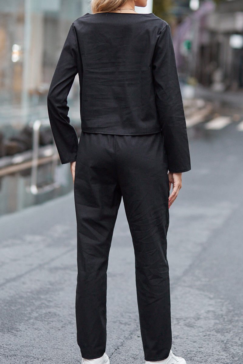 Back view of a woman wearing a black 100% cotton linen monochrome two-piece set with long sleeves and pants.