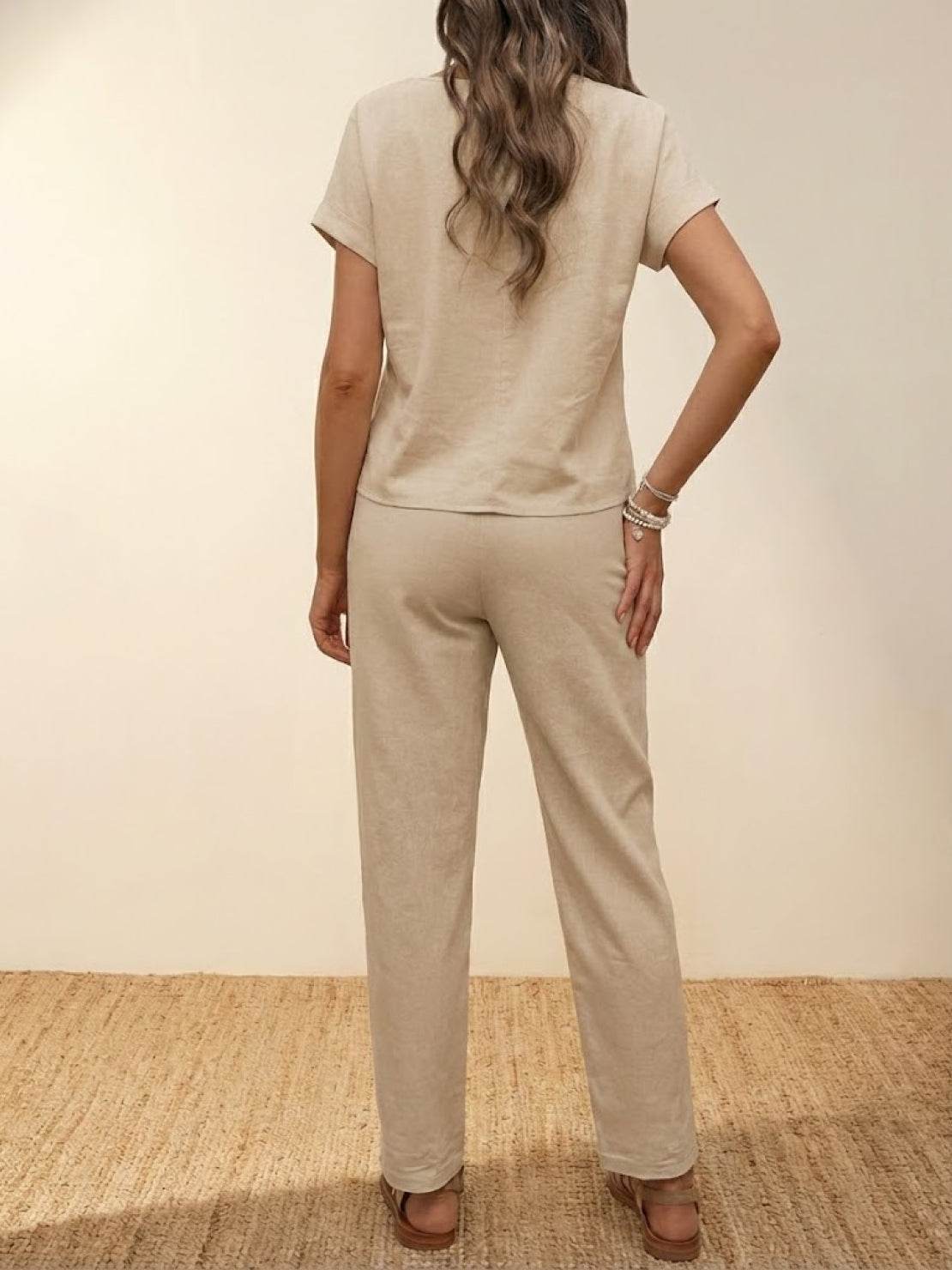 Woman wearing beige 100% cotton total comfort two-piece set with short sleeves and long pants, back view.