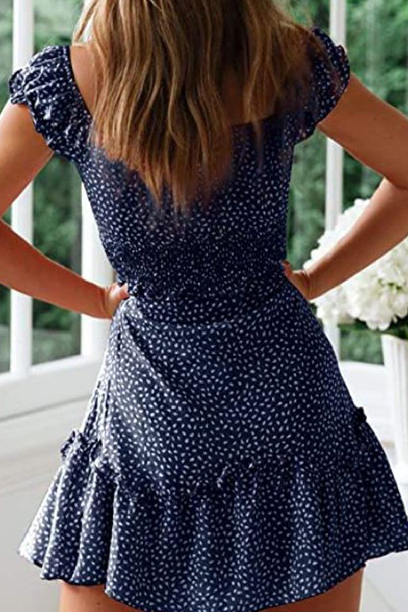 Back view of woman wearing navy blue sweetheart collar printed ruffled maxi dress with short sleeves and high waist design.