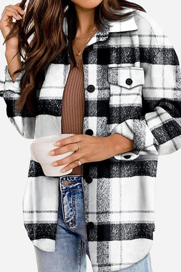 Woman wearing stylish black and white long sleeve plaid flannel jacket with buttons and chest pockets holding a cup