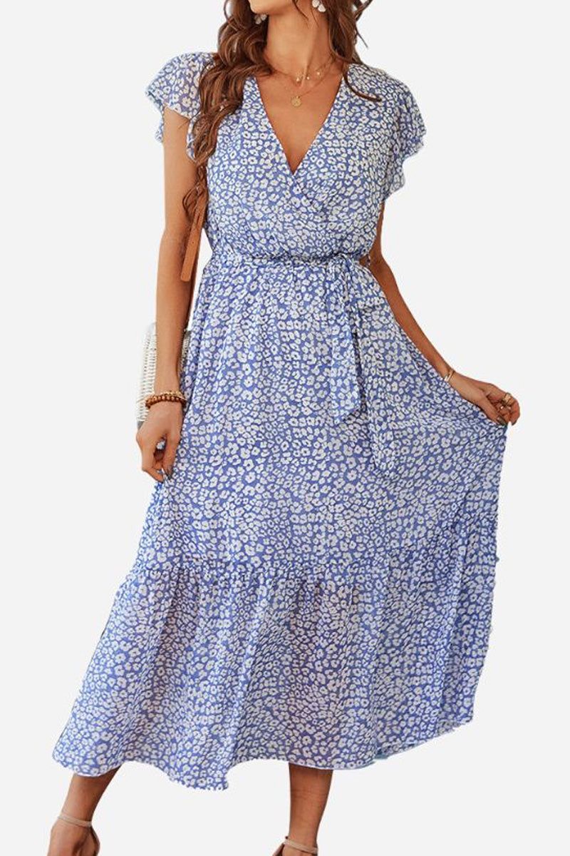 Woman wearing Elegant Blossoms Boho Maxi Dress with floral pattern, V-neck, short sleeves, and belted ruffle hem in soft blue tones.