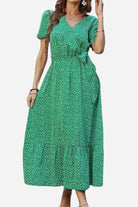 Charming Floral Boho Maxi Dress in green with white floral print, wrap V-neck, belted waist, and ruffle hem.