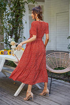 Woman wearing a red Charming Floral Boho Maxi Dress with short sleeves and flowing skirt outdoors on patio