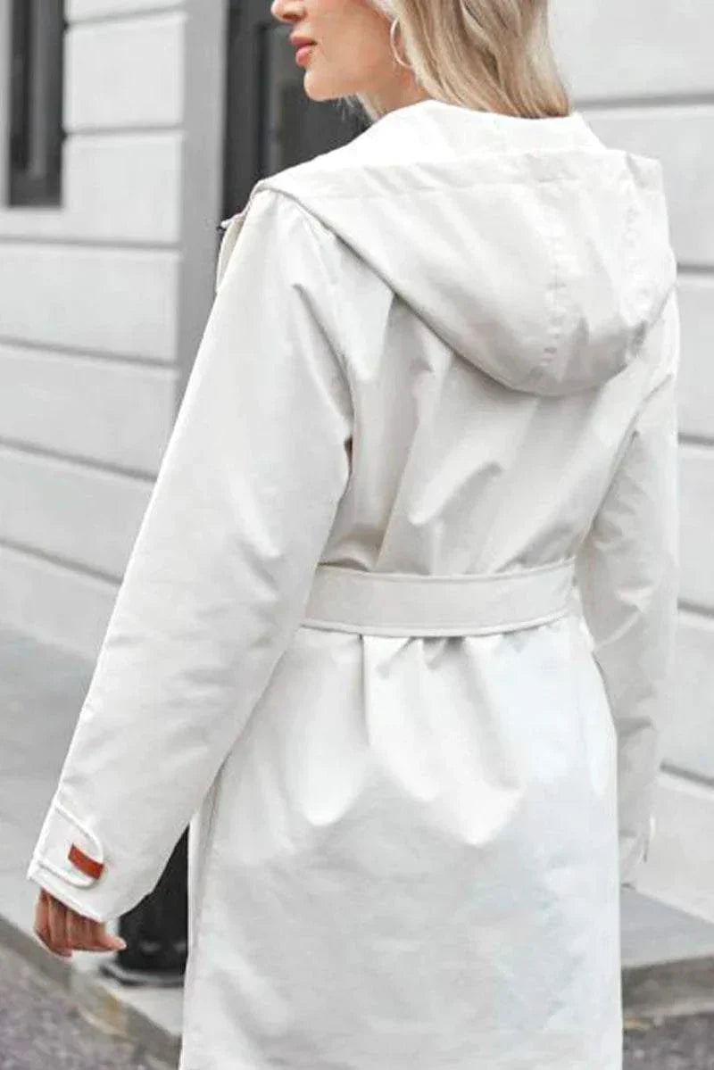 White water-resistant windbreaker trench jacket with hood and adjustable belt on woman outdoors