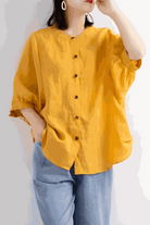 Relaxed loose breathable linen blouse in vibrant mustard yellow with button-down front and 3/4 sleeves.