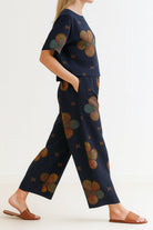Woman wearing navy floral loose fit co-ord set with wide-leg trousers and short-sleeve top, styled with brown sandals.