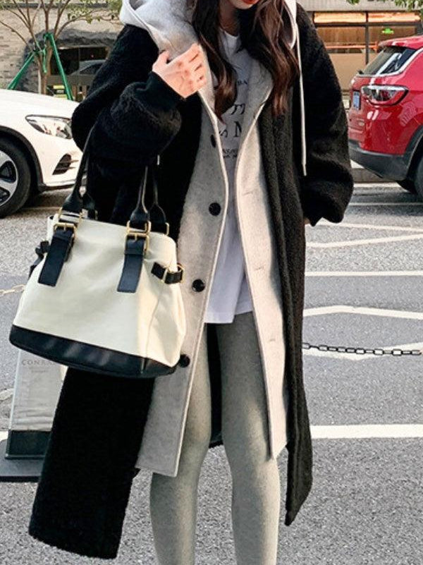 Woman wearing everyday wear oversized sherpa long coat with cozy lining and casual outfit carrying a white and black handbag outdoors