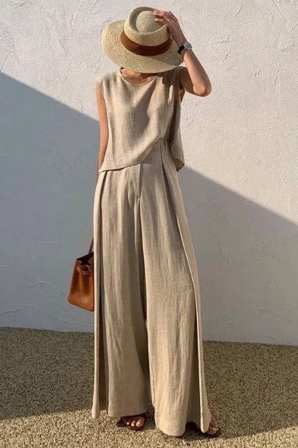 Woman wearing Casual Radiance Loose-Fit Combo beige cotton linen top and wide-leg pants with straw hat and brown handbag.