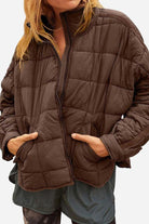 compact lightweight puffer travel jacket in black with sleek design and zippered pockets