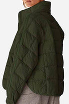 lightweight puffer travel jacket in olive green with quilted design and high collar