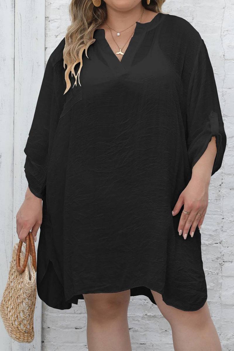 Woman wearing black airy V-neck tunic with 3/4 sleeves and asymmetrical hem holding a woven bag.
