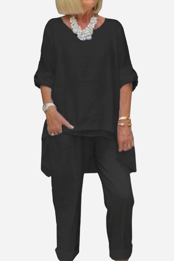 Black asymmetrical two-piece trouser set with loose top and tapered pants for women.