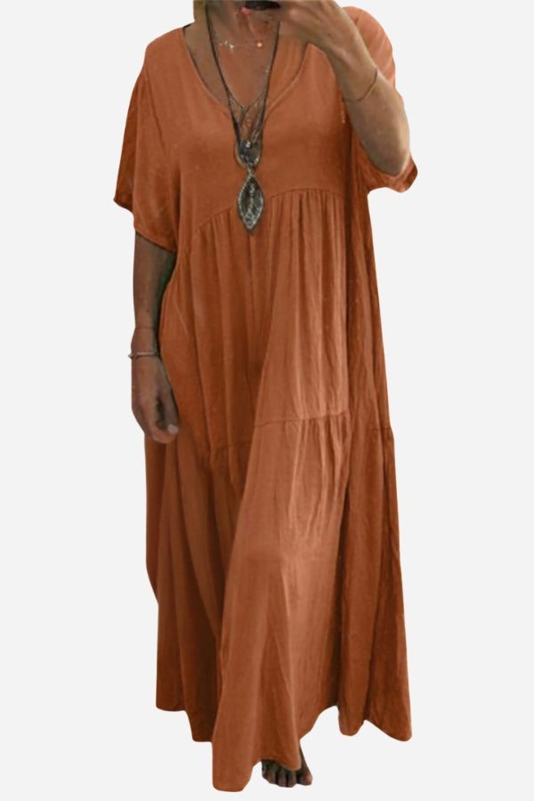 Rust-colored V-neck two-tiered maxi swing dress with loose sleeves, flowy tiers, and casual bohemian style