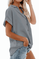 Grey V-neck collared button blouse with rolled short sleeves and casual fit worn with denim shorts
