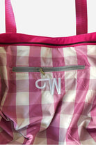 Pink and white checkered waterproof travel bag interior with zipper pocket and pink handles