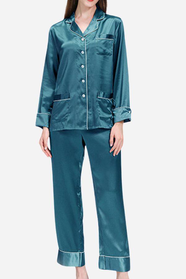 Woman wearing teal long sleeve silk pajamas with button-up top and full-length pants
