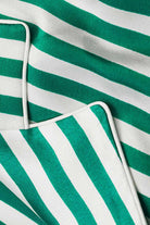 Close-up of green and white striped 100% mulberry silk fabric with piping detail