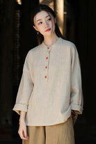 Woman wearing natural beige ramie linen and cotton blouse with long sleeves and wooden buttons