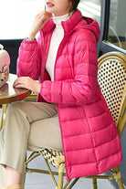Women's lightweight water-resistant hooded puffer coat in vibrant pink, ideal for travel and everyday warmth.