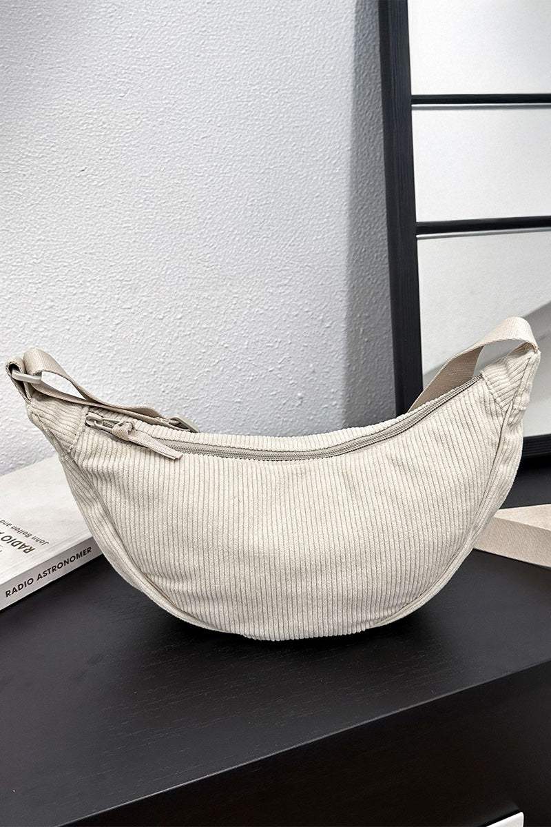 Beige corduroy shoulder bag with adjustable strap and zip closure, soft ridged texture, lightweight and roomy design.