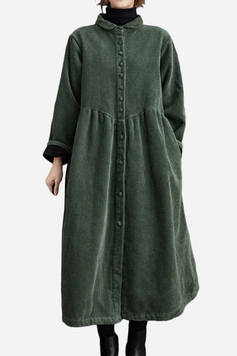 Oversized vintage corduroy coat in green with button front and long sleeves, styled layered over black turtleneck and pants