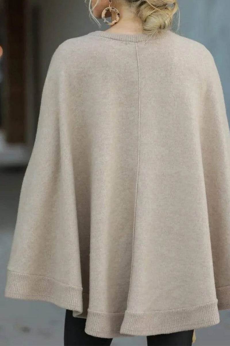 Back view of beige elegant poncho pullover made from soft, lightweight fabric with relaxed fit and ribbed edges
