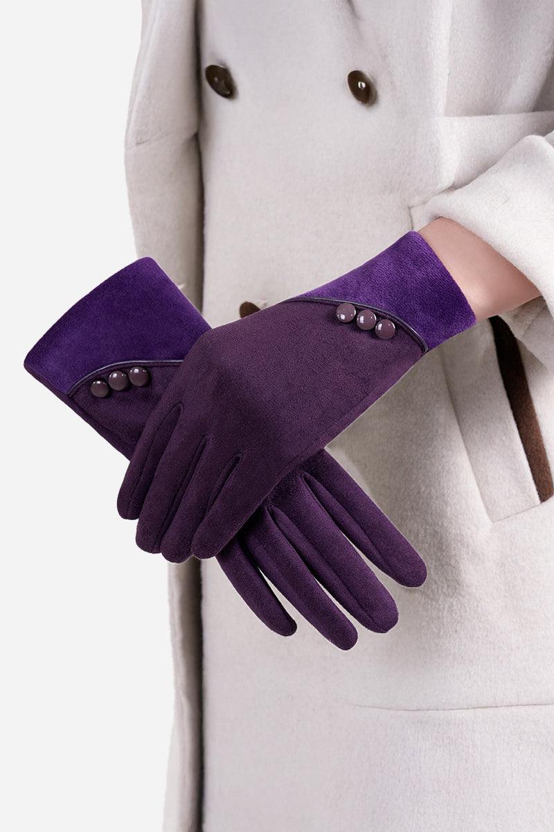 Purple SmartTouch suede gloves with button details worn by a person in a beige coat