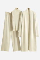 Beige one size fits all three-piece collection with ribbed turtleneck, wide-leg pants, and long open cardigan.