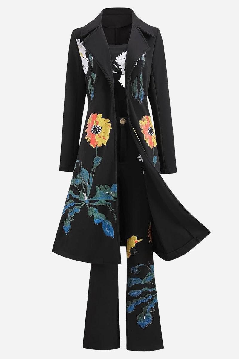 Black three-piece floral set with long coat, strapless top, and pants featuring colorful flower prints