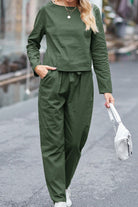 woman wearing green Casual Chic Duo two-piece relaxed shirt and trousers set walking outdoors with white handbag