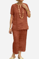 Woman wearing rust-colored breezy cotton blend two-piece set with short sleeves and relaxed fit pants