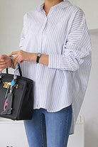 100 cotton oversized striped shirt worn with blue jeans and black handbag