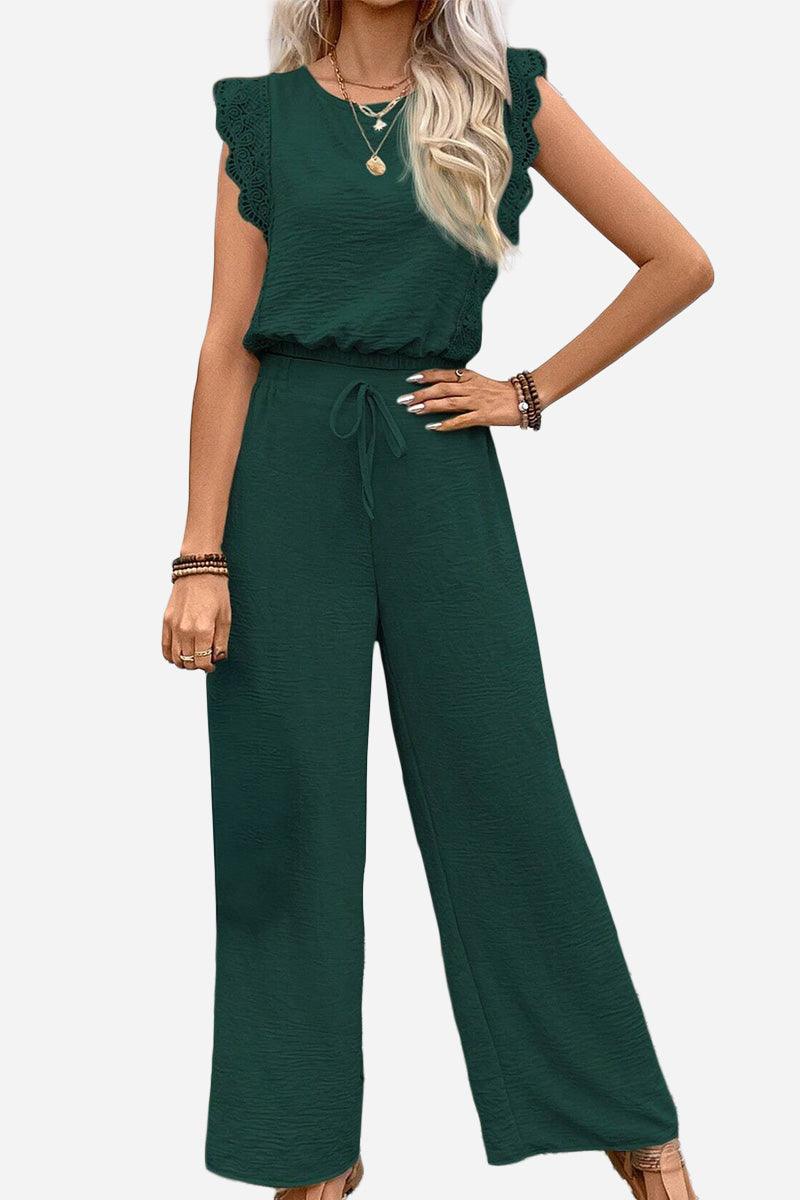Woman modeling an elegant two-piece set in dark green with lace details and wide-leg pants