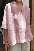 Woman wearing relaxed fit cotton-linen V-neck shirt in soft pink with half sleeves.