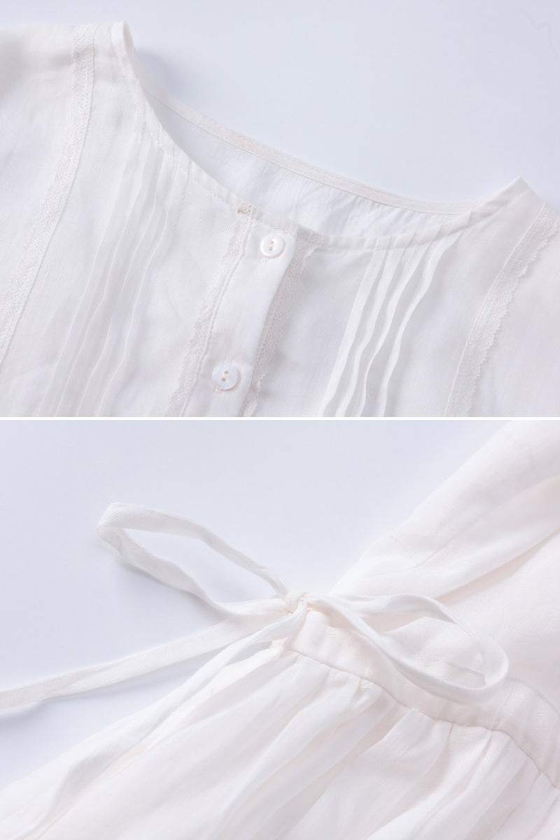 Close-up of white 100% linen coastal shift dress showing button front and waist tie detail