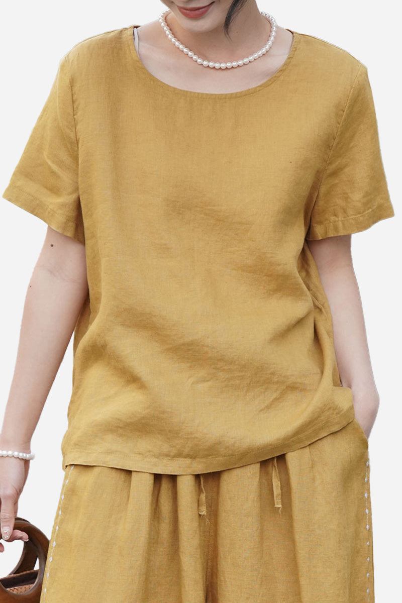 Woman wearing a breathable 100 pure linen mustard yellow classic short sleeve shirt with a round neckline.