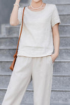 Woman wearing a breathable classic shirt and pants set made of 100 pure linen fabric.