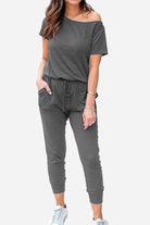 Woman wearing Moonlit Rome Off-Shoulder Jumpsuit in gray with pockets and tapered pants