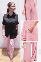 Woman wearing oversized linen leaved-IN set with black linen-blend shirt and pink flowy palazzo pants with pockets and elastic waistband.