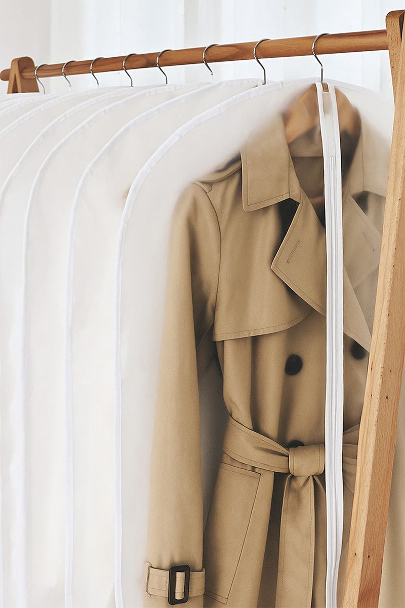 Waterproof dustproof clothing cover protecting beige trench coat on wooden hanger rod