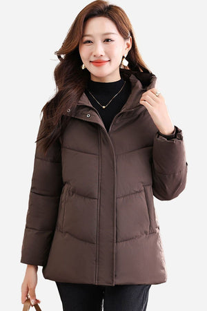 Woman wearing a brown mid-length hooded Everyday Warmth Coat with 5-layer thermal insulation and wind-resistant shell