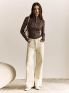 Woman wearing a slim-fit ribbed zip-up knit cardigan jacket with high neckline and long sleeves