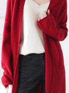 Long Australian Merino wool cardigan with open front, patch pockets, and ribbed cuffs.