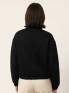 Cropped textured baseball jacket with full zipper, stand collar, elastic cuffs and waistband, styled for casual wear.