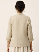 Cotton-linen blazer with relaxed fit, notch lapels, two-button closure, and natural textured fabric