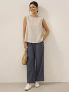 Lightweight 100% cotton-linen sleeveless top with round neckline and back button closure for warm weather layering