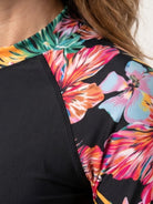 Two-piece tropical print rash guard set with long-sleeve top and matching boy-cut swim shorts