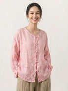 Oversized 100% linen blouse with frog-button closure, collarless neckline, long sleeves, and curved hem in lightweight semi-sheer fabric