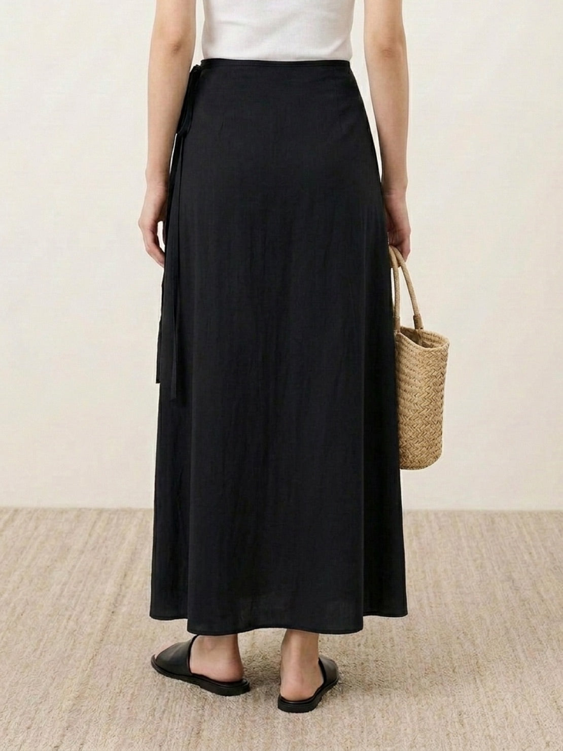 woman wearing asymmetrical wrap maxi skirt with side tie closure and asymmetric hem in casual outdoor setting